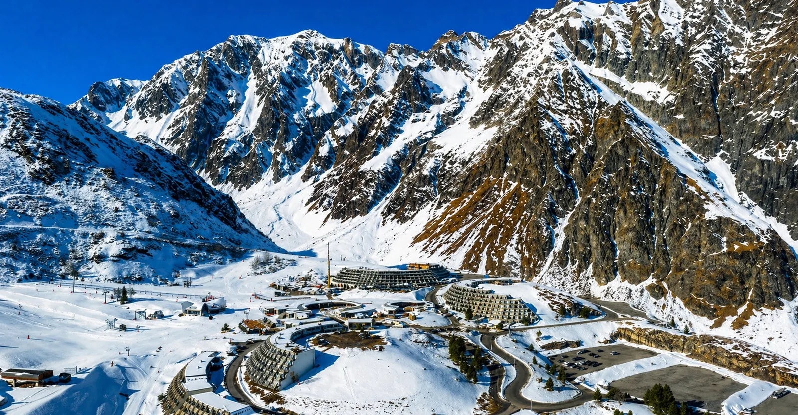 Vue de Piau-Engaly en altitude avec résidences de station, front de neige et montagnes enneigées